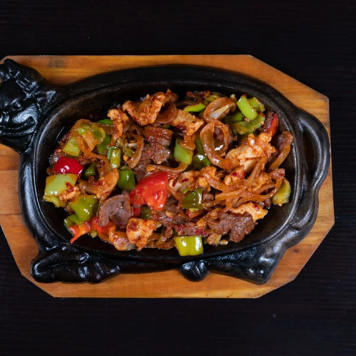 Res salteada al wok con pimientos servida en plancha de hierro