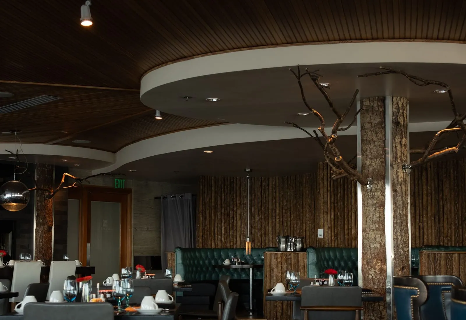 Mesas del salón servidas, con luz cálida sobre los manteles