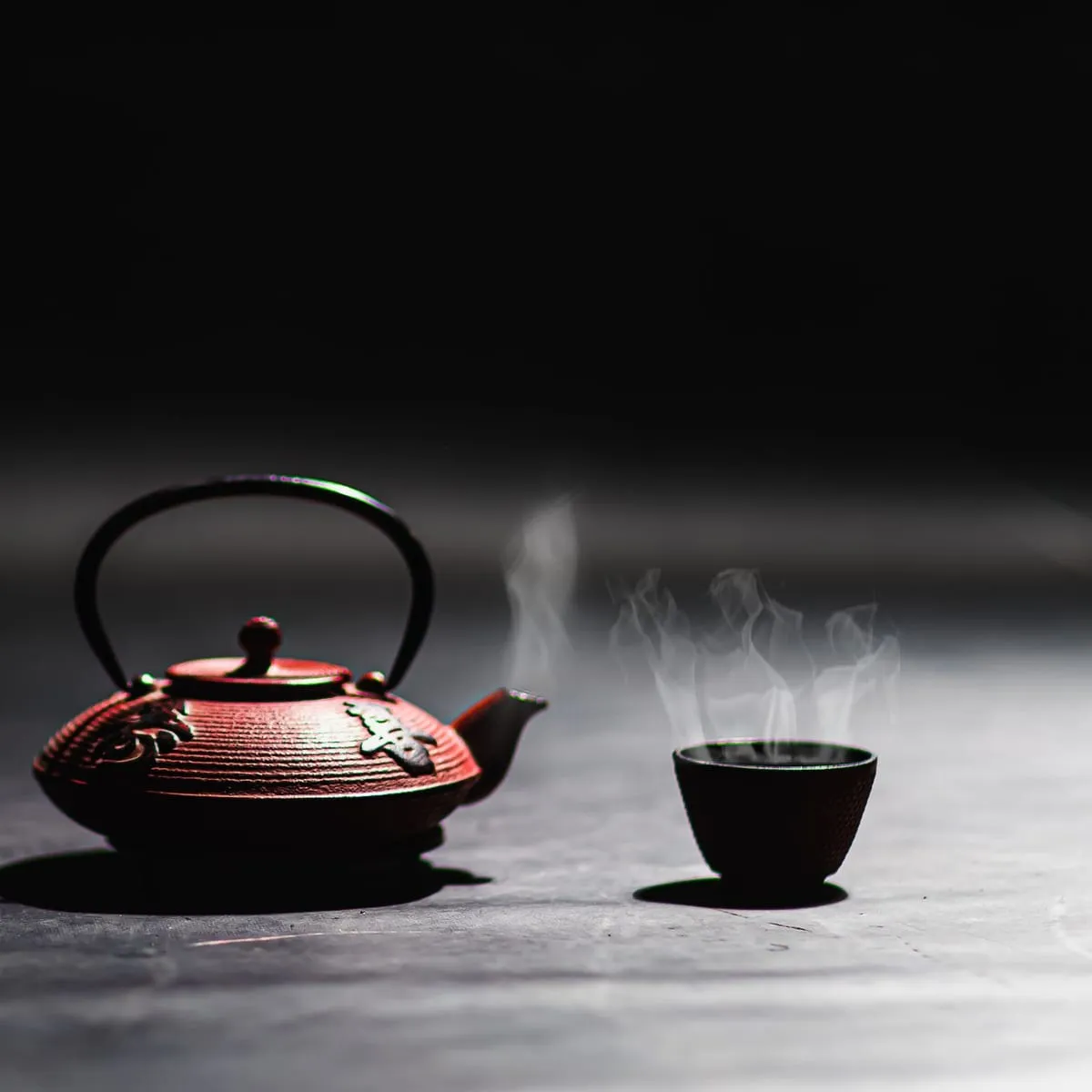 Tetera de hierro con té chino servida sobre la mesa